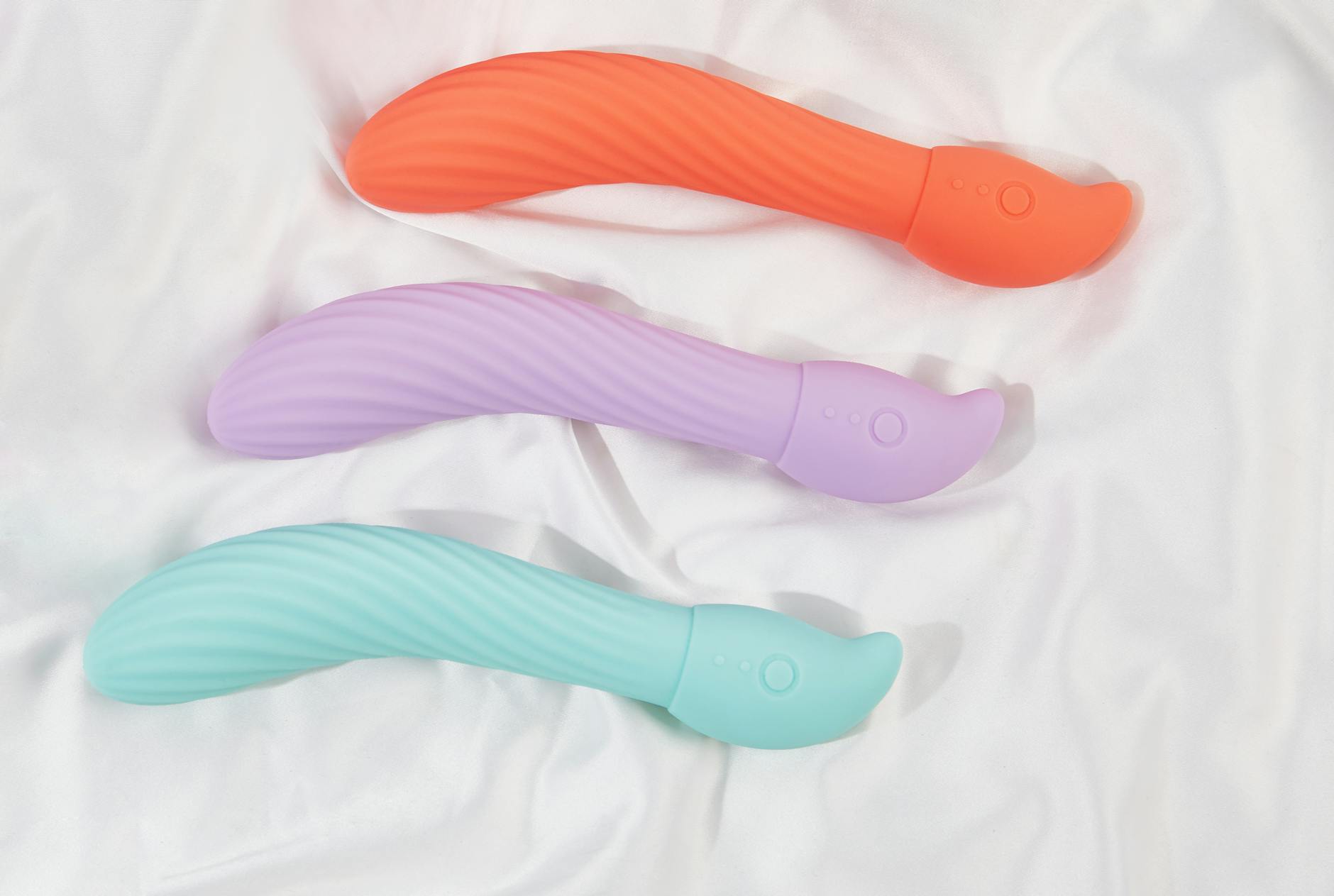 A stylish teal vibrator on smooth white silk fabric for relaxation and tension relief.