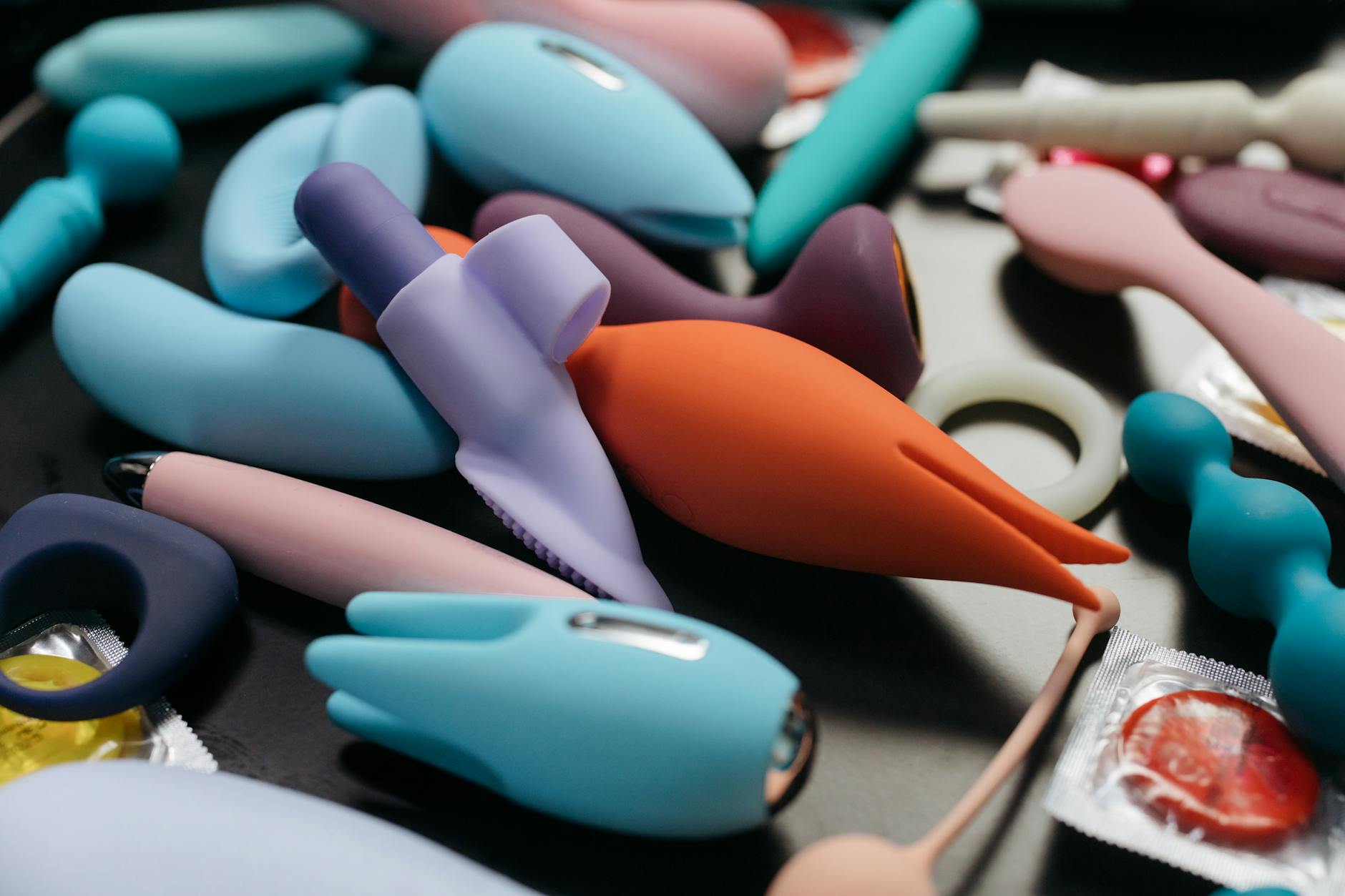 Close-up of a woman holding a pink vibrator with art books in background
