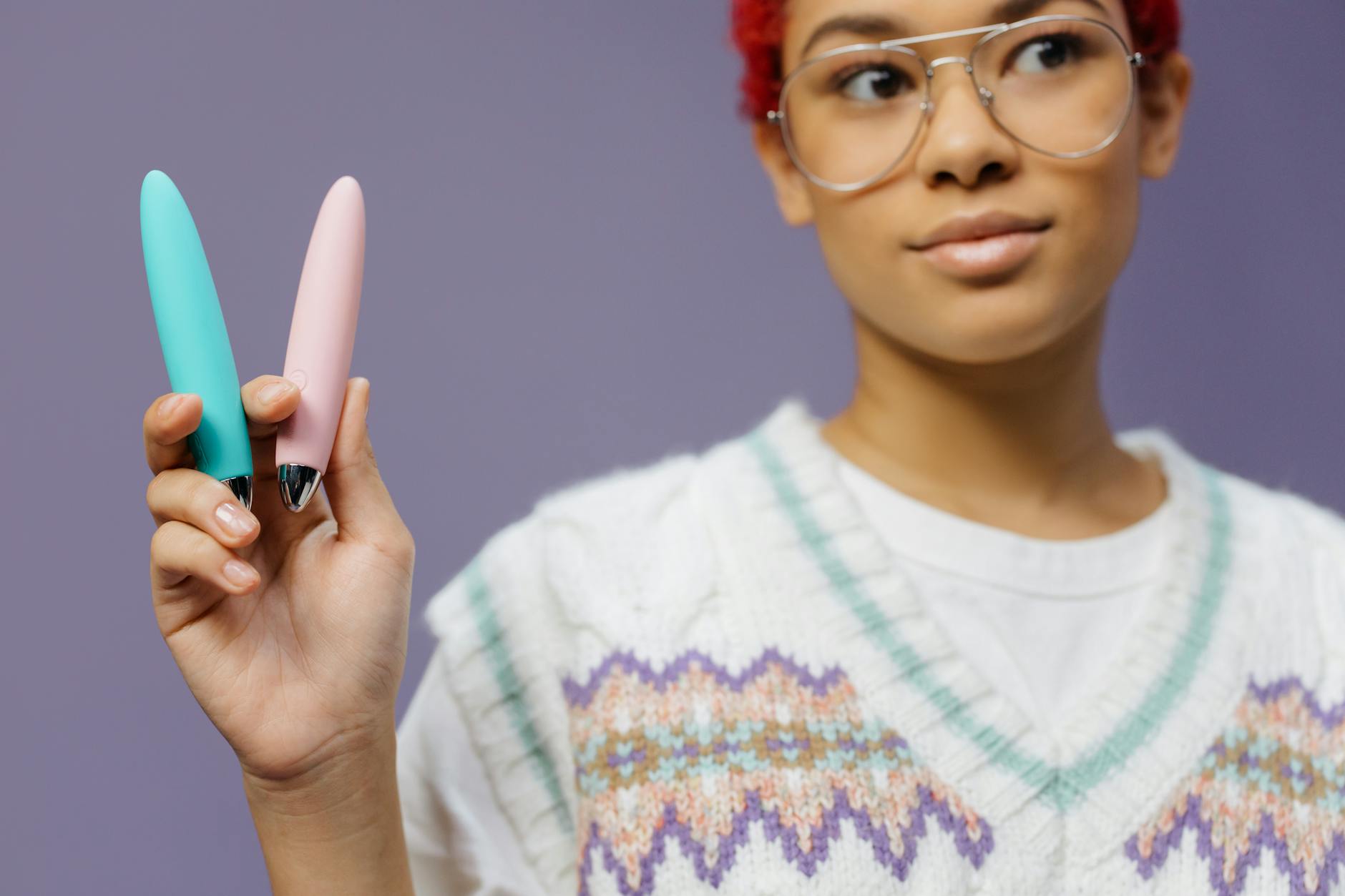 Woman holding colorful vibrators for clitoral pleasure comparison