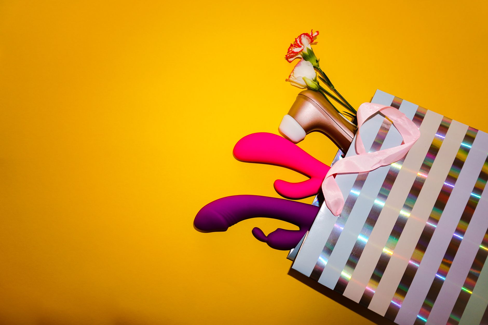 A young couple standing together indoors, holding a vibrator, symbolizing shared intimacy and modern relationships