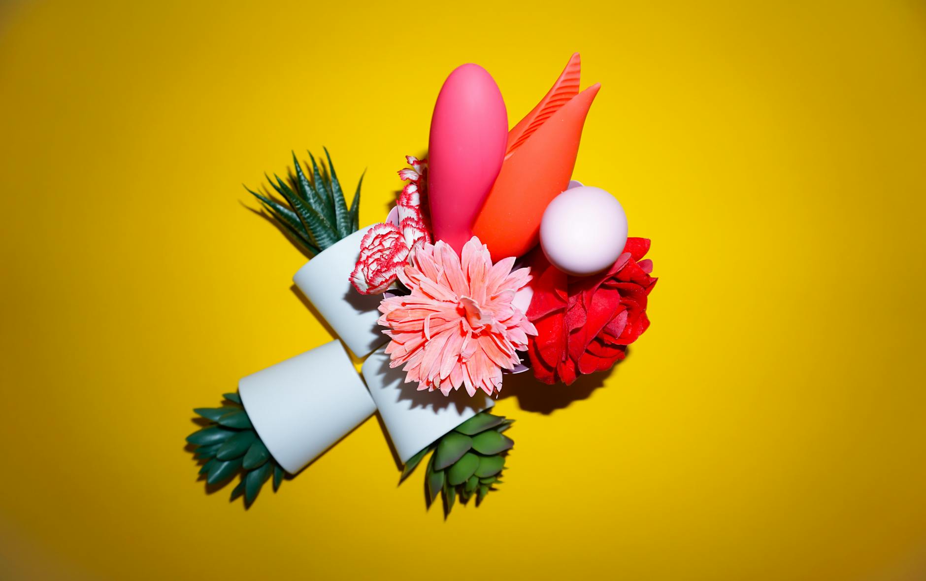 Studio arrangement of colorful vibrators on a bright yellow background