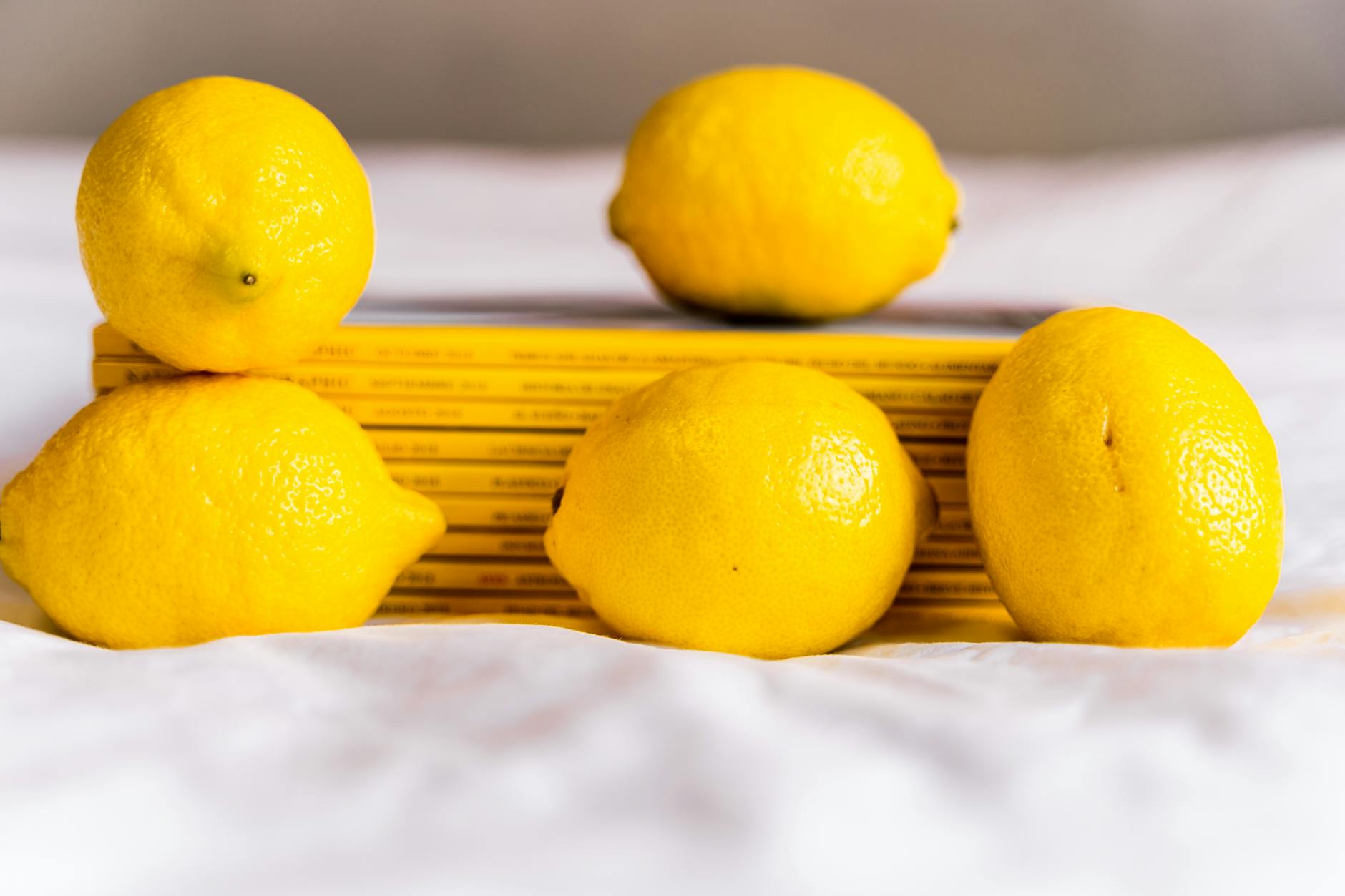 Fresh lemons arranged with books on white surface, symbolizing natural aging and wellness